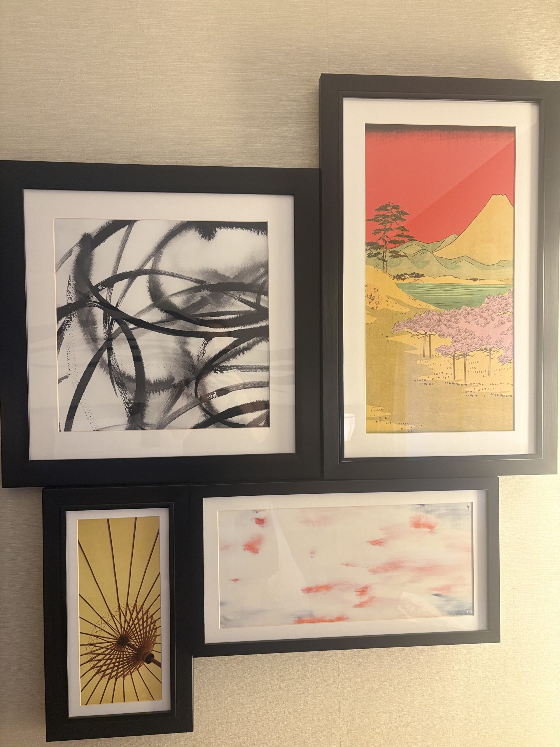 Gallery wall of framed Japanese-inspired art prints including a red-sky mountain scene and a paper umbrella detail