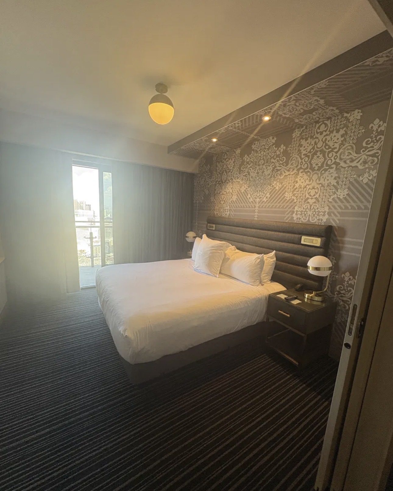 Cosmopolitan Las Vegas hotel room with king bed, patterned accent wall, and private balcony