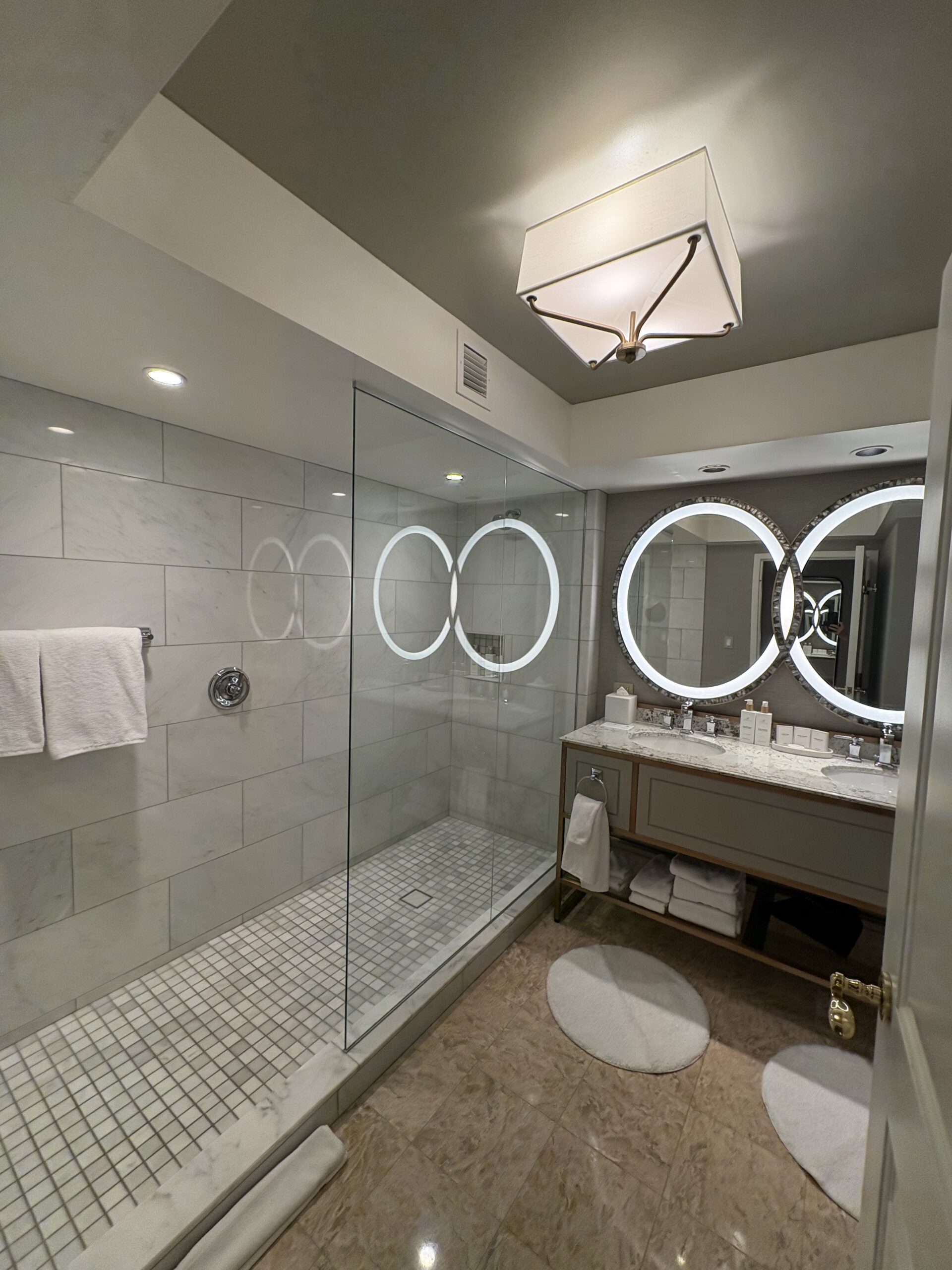 Bellagio bathroom double vanity and glass-enclosed walk-in shower