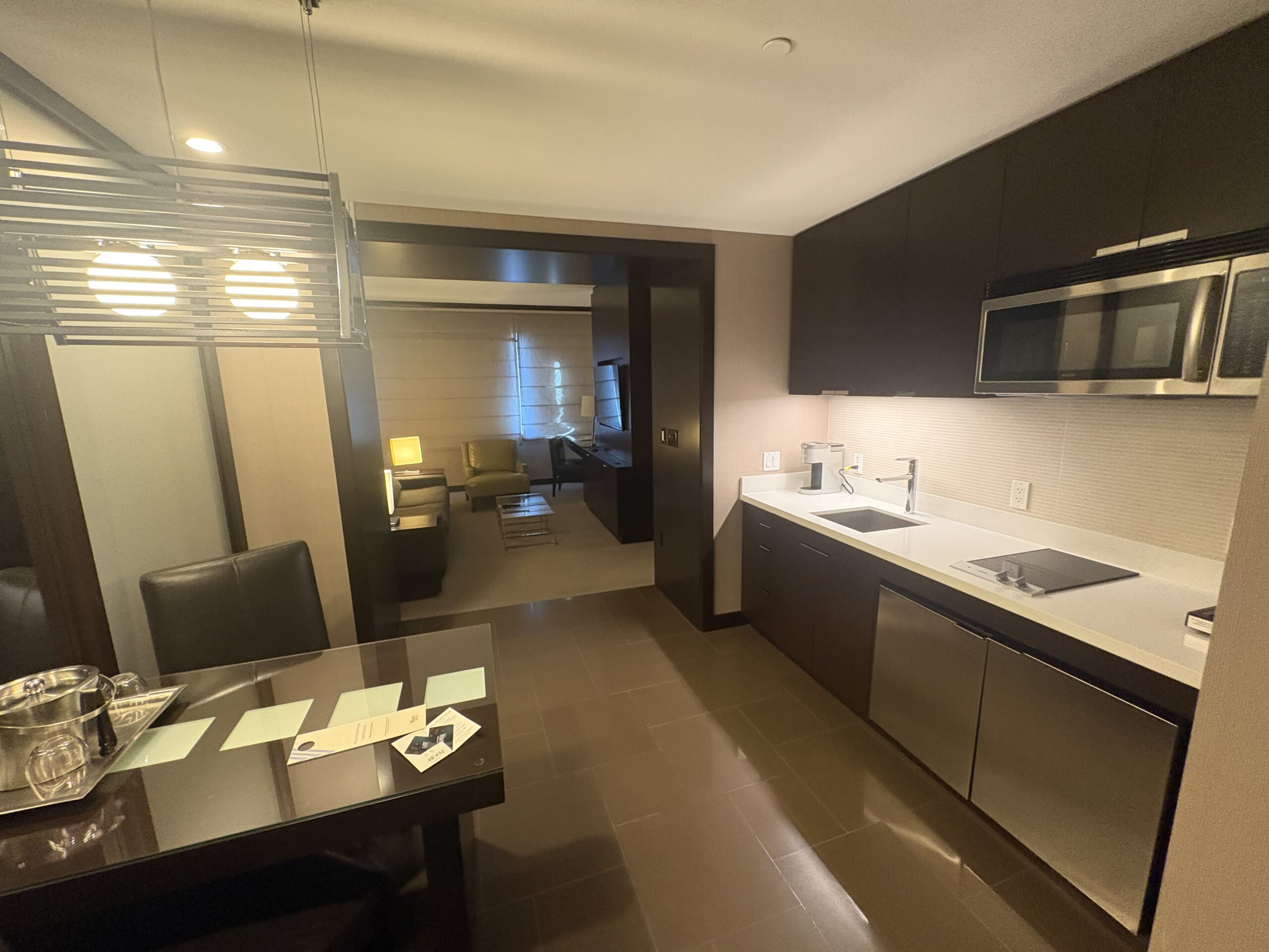 Vdara Studio Parlor Suite kitchenette with stainless fridge, cooktop, and dining table