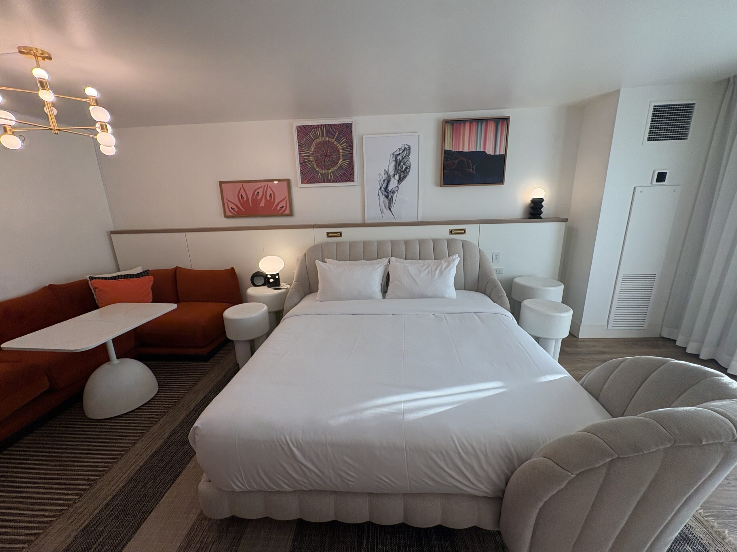 Channel-tufted king bed below a gallery wall of artwork at Virgin Hotels Las Vegas