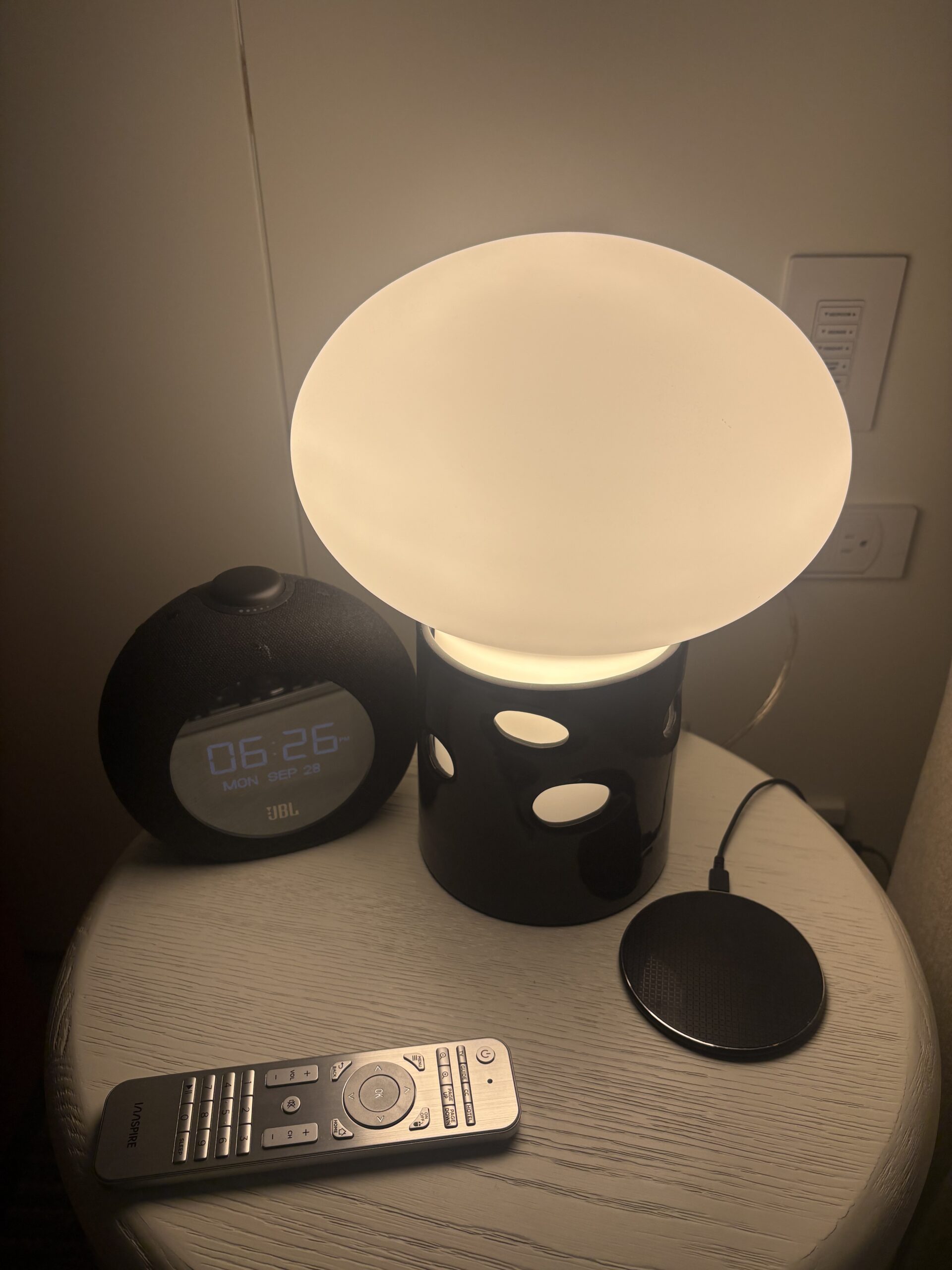 Nightstand with mushroom lamp, JBL clock speaker, and wireless charging pad