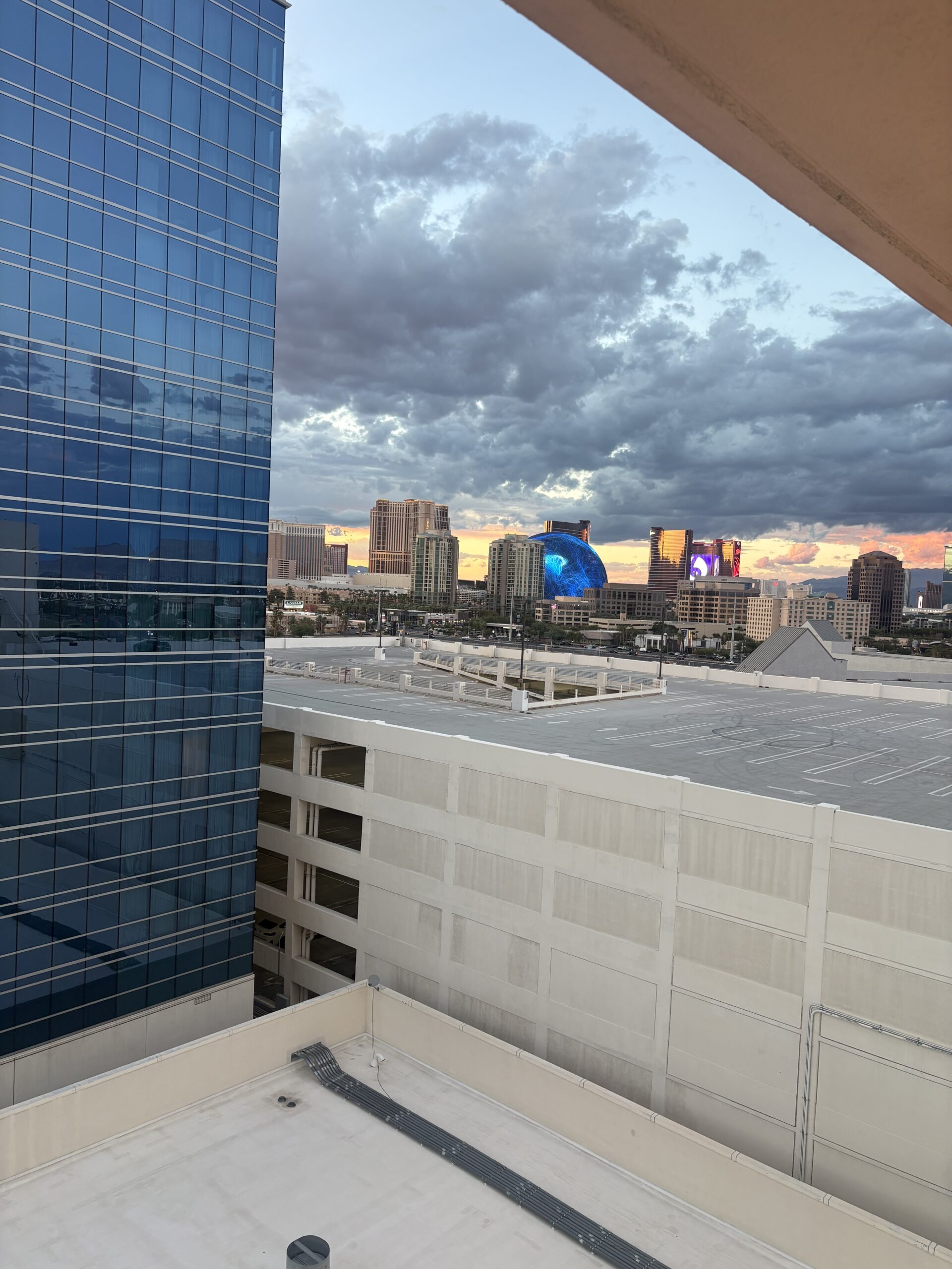 The Sphere glowing blue between Strip towers, seen from Virgin Hotels Las Vegas