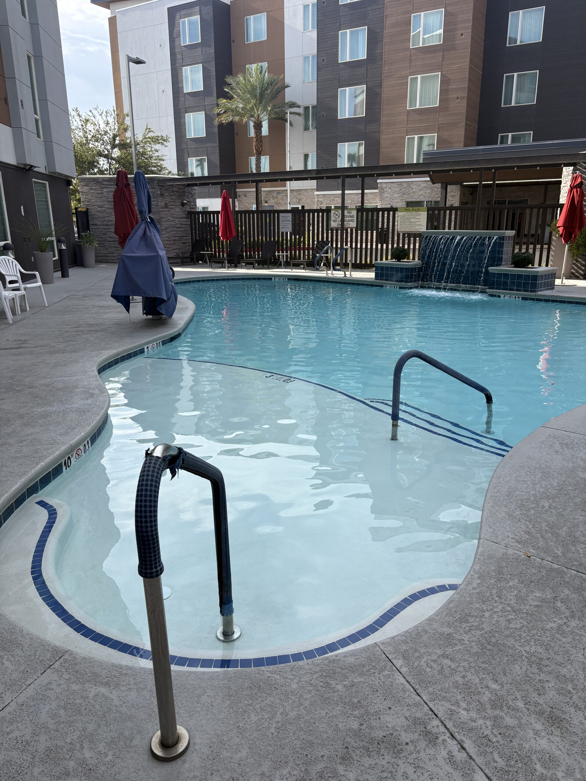 Outdoor pool with waterfall feature at Home2 Suites Las Vegas Stadium District