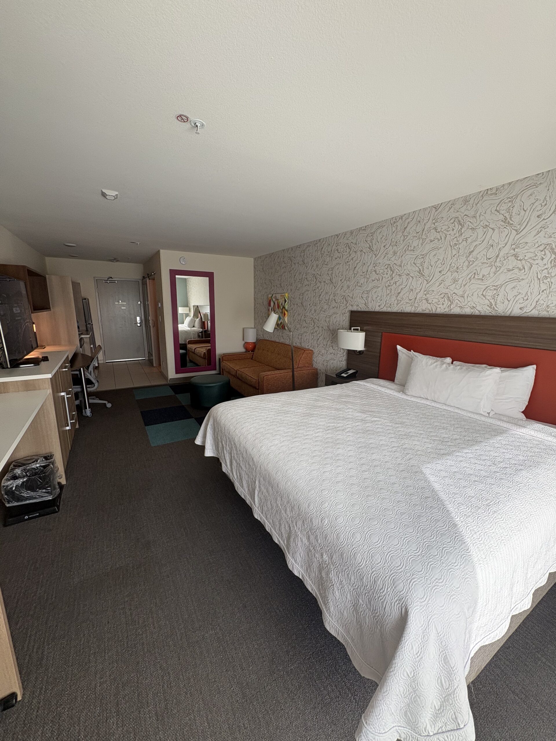 King bed with orange headboard in Home2 Suites by Hilton Las Vegas Stadium District room