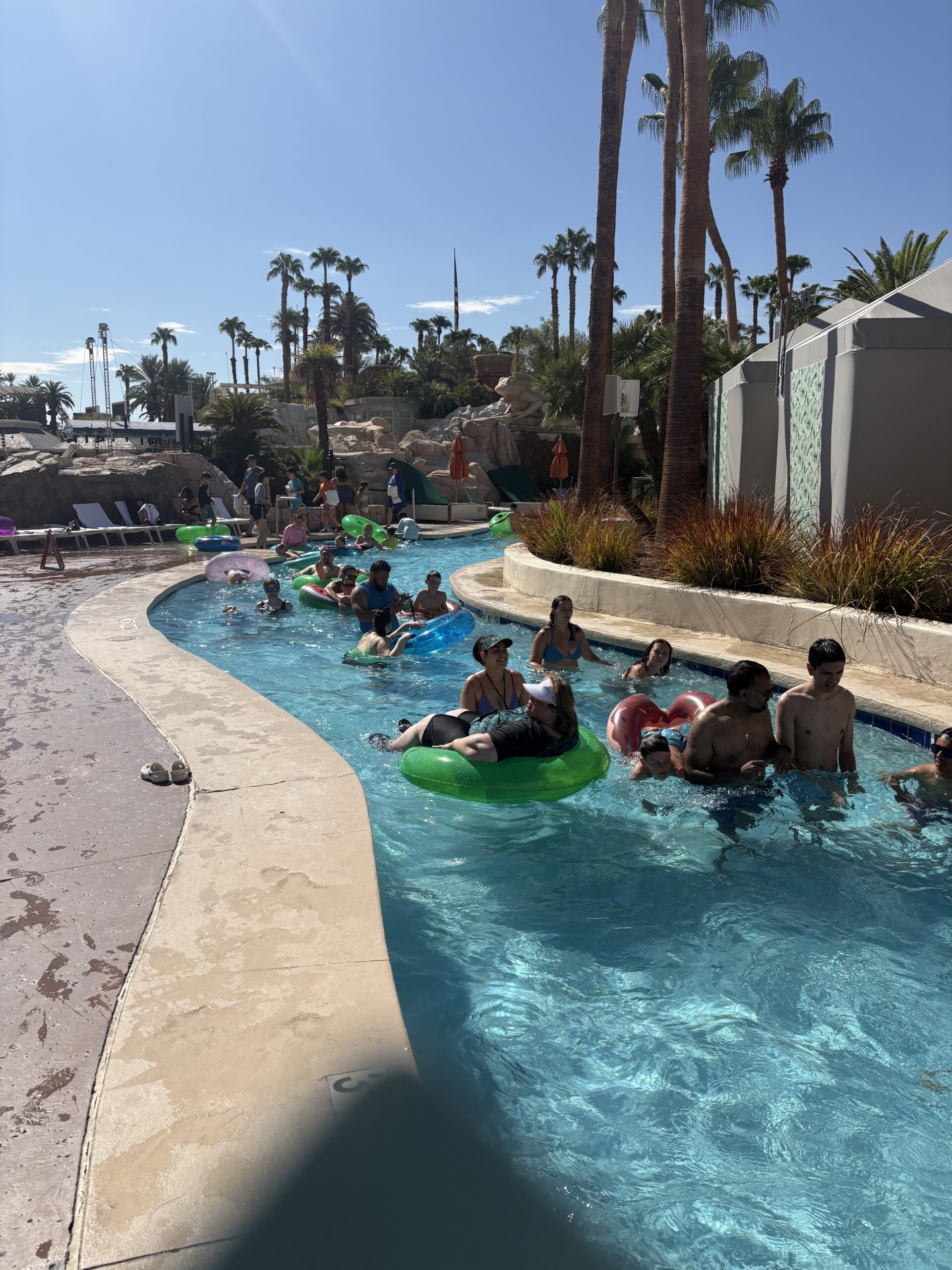 Guests floating on tubes down the lazy river at Mandalay Bay Las Vegas under palm trees