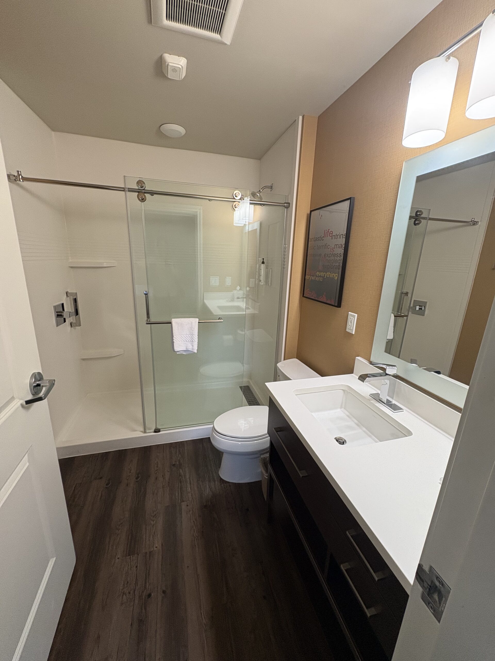 Glass-enclosed shower and vanity in a TownePlace Suites bathroom near Allegiant Stadium