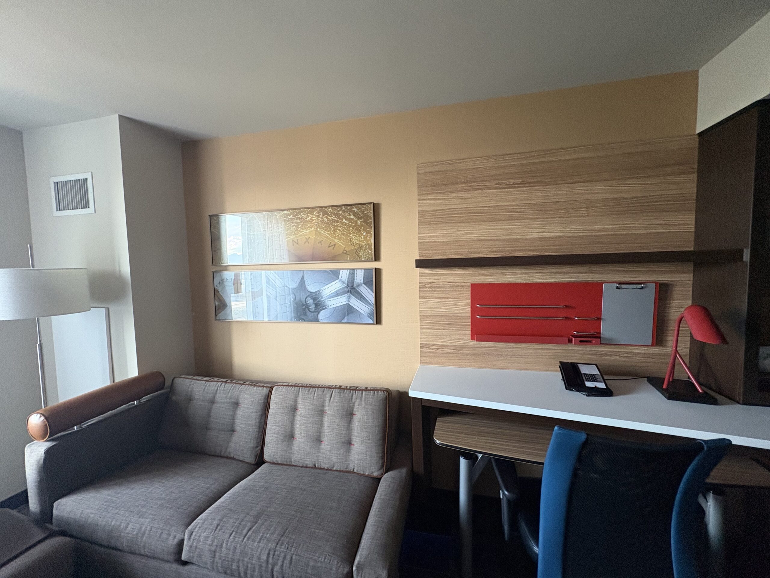 Pull-out sofa and desk workspace in a TownePlace Suites living area near Allegiant Stadium