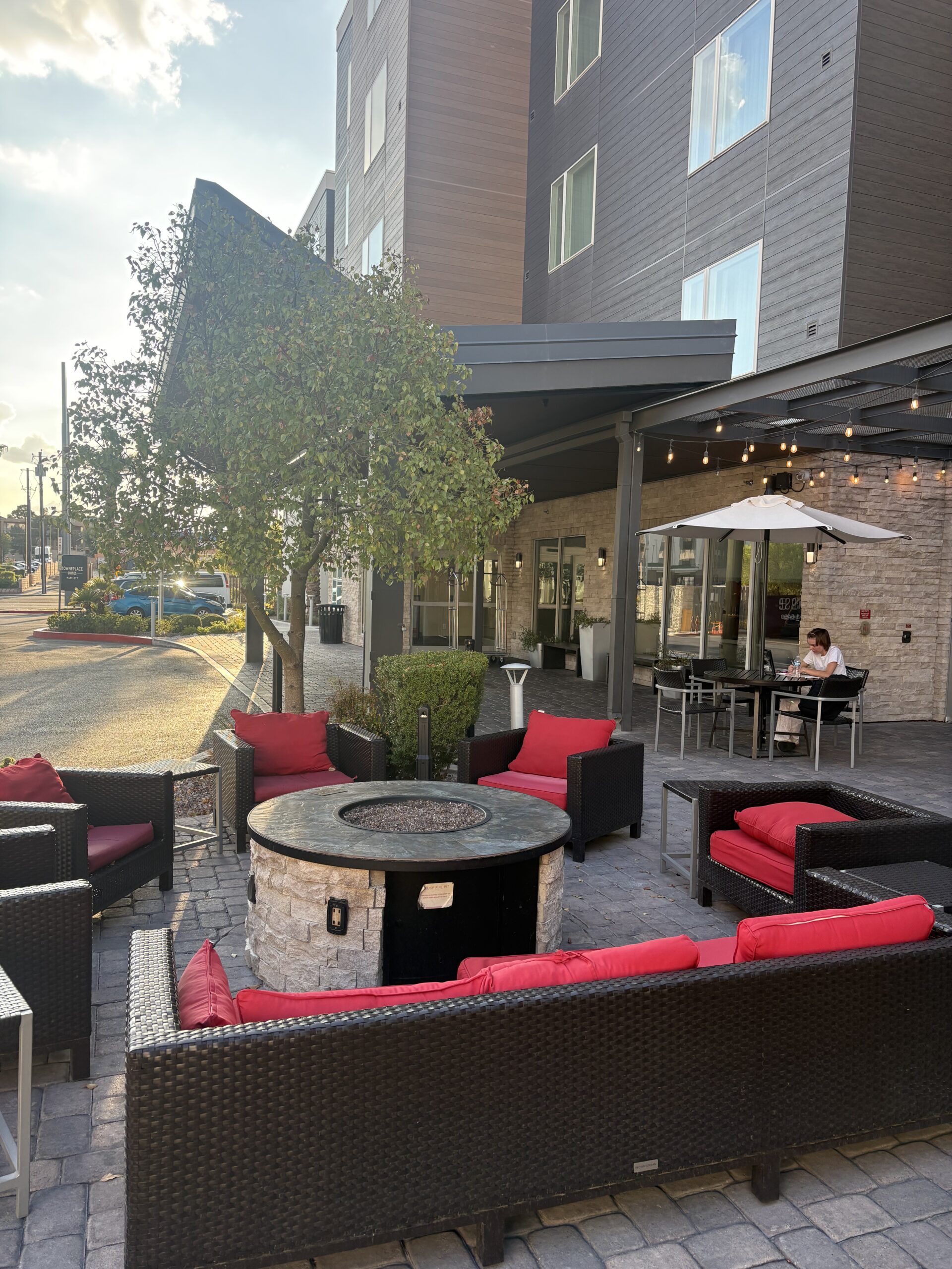 Outdoor fire pit lounge with string lights at TownePlace Suites courtyard