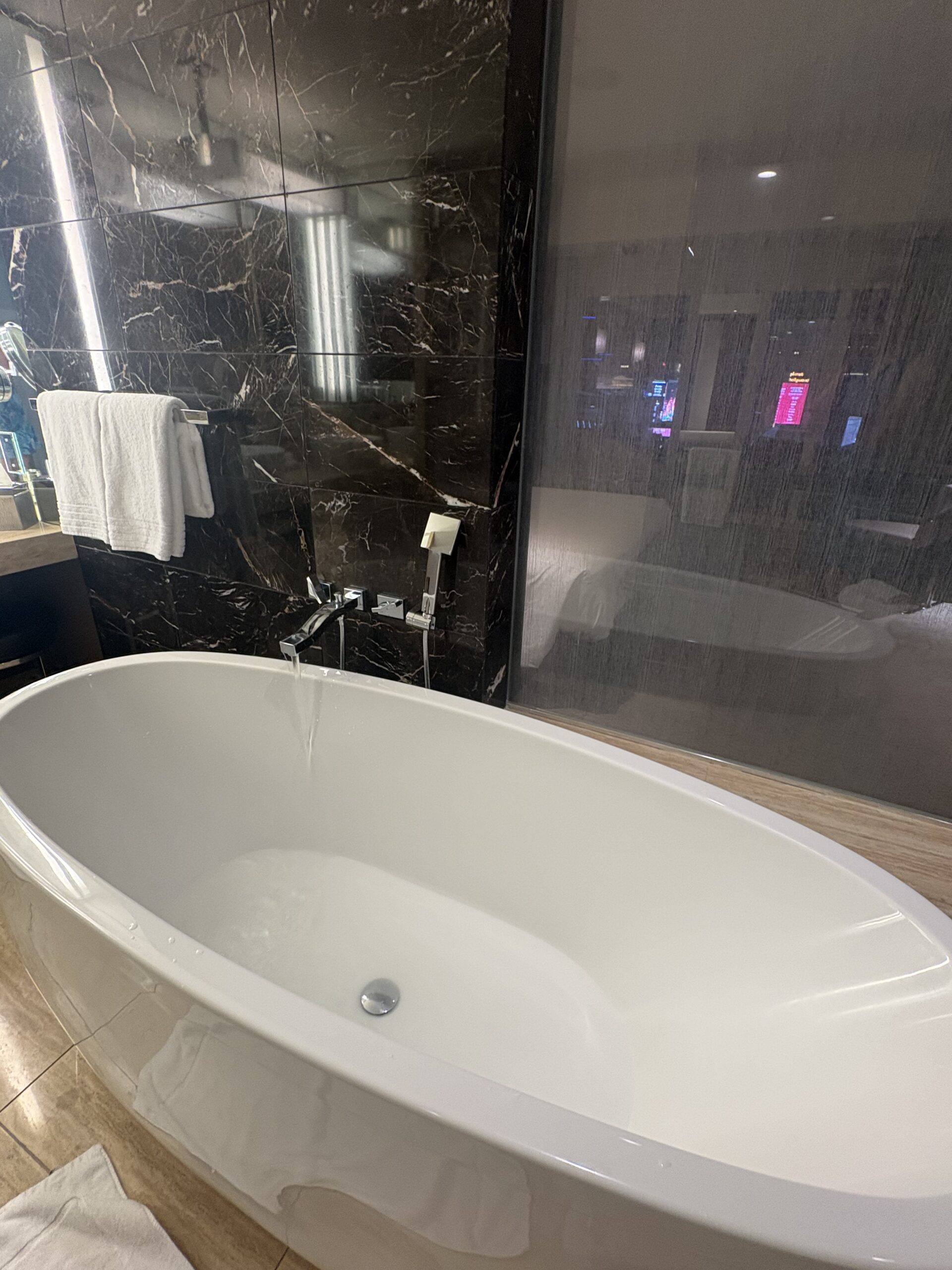 Soaking tub with sliding glass privacy screen and Strip view at Waldorf Astoria Las Vegas