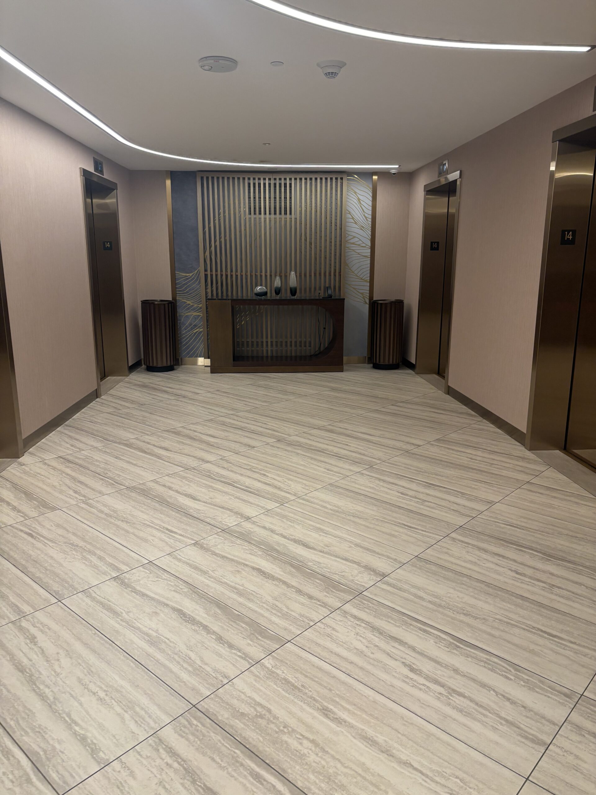 Elevator lobby with curved ceiling lighting and a decorative console at Conrad Las Vegas