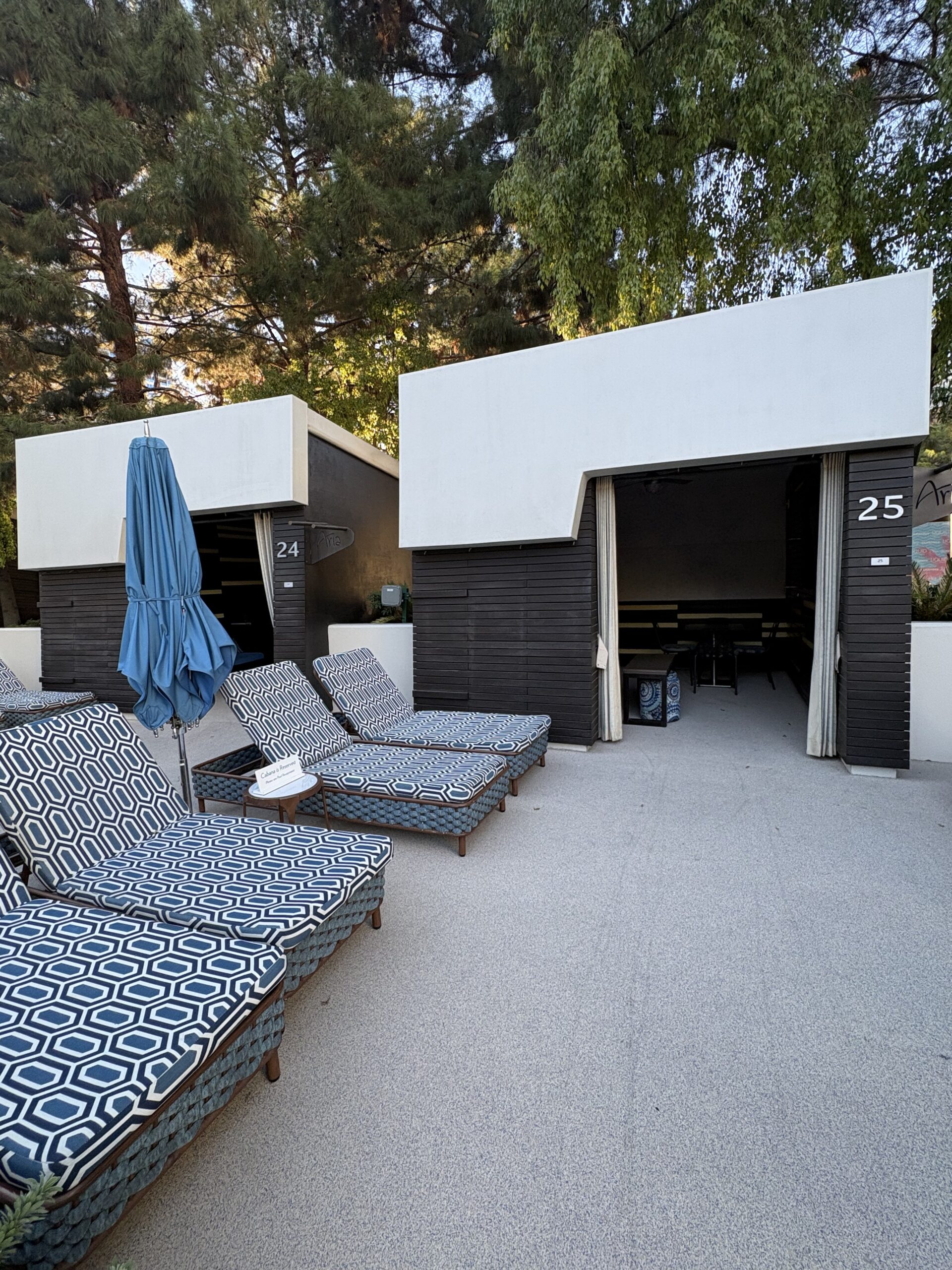 Numbered cabanas with patterned loungers at the Aria pool