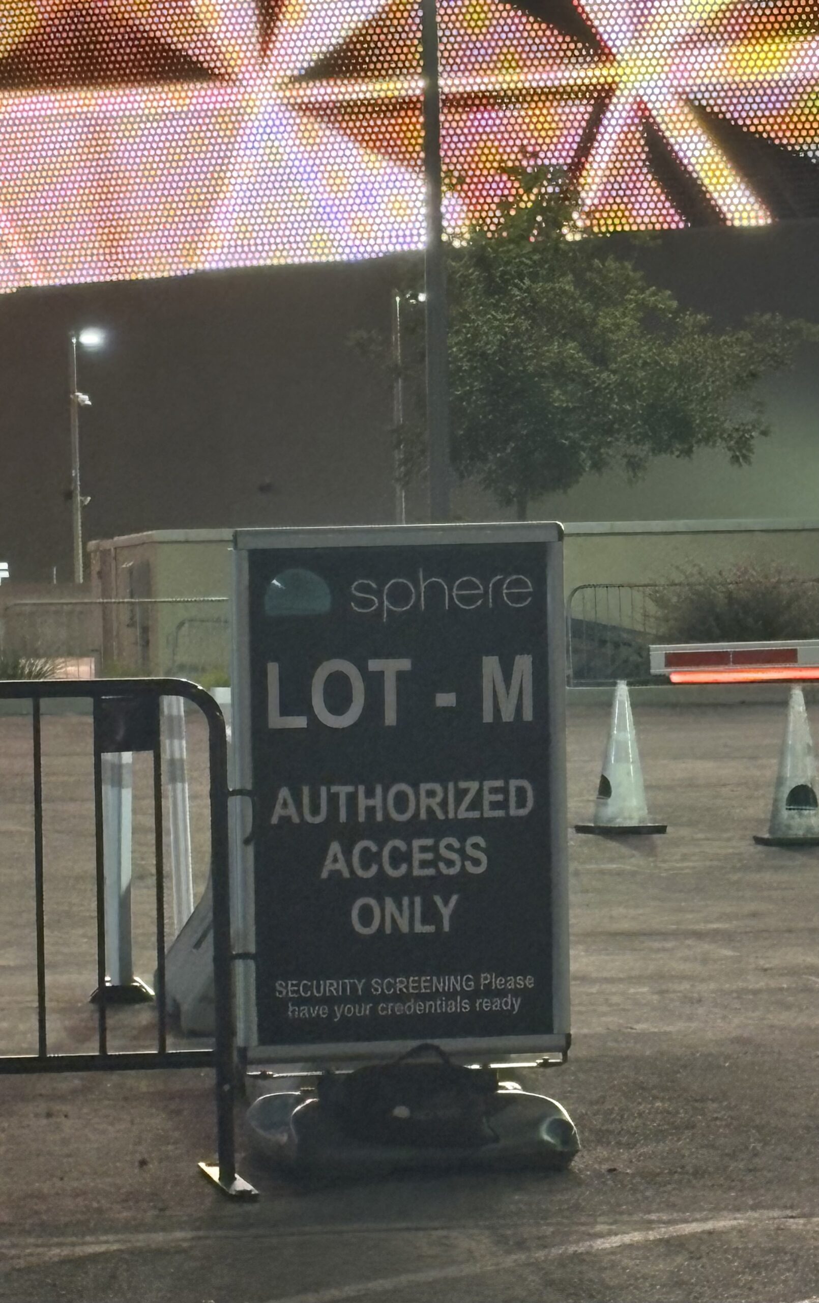 Sphere Lot M sign reading authorized access only, with security screening, in front of the lit Sphere