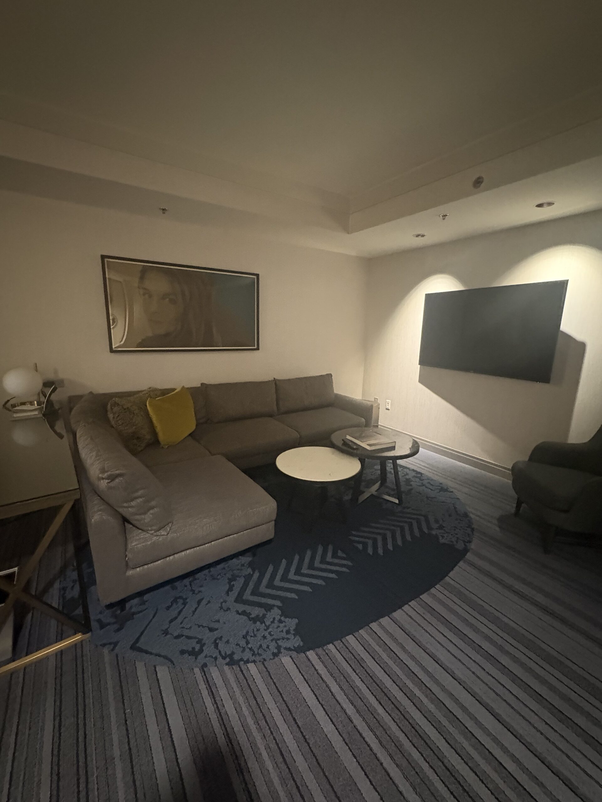 Living area with a sectional sofa, round coffee tables and a wall-mounted TV in a Cosmopolitan Las Vegas room